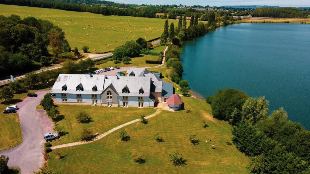 eine Luftansicht eines großen Hauses auf einer Insel in einem See in der Unterkunft Eden Park Hotel Restaurant in Pont-lʼÉvêque