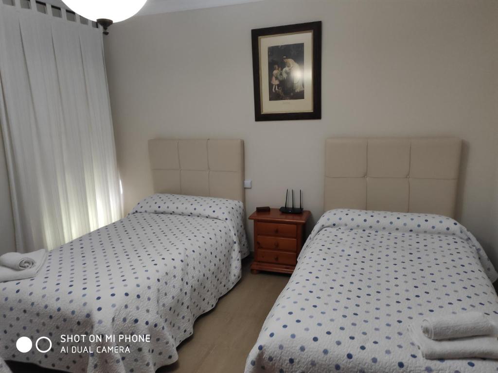 sypialnia z 2 łóżkami i zdjęciem na ścianie w obiekcie La Casa Del Rio w mieście Setenil
