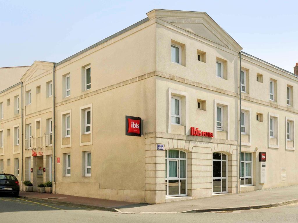 a building with a sign on the side of it at ibis Rochefort in Rochefort