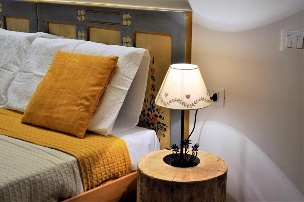 a bedroom with a bed and a lamp on a table at Appartamento Dolomella in Fai della Paganella