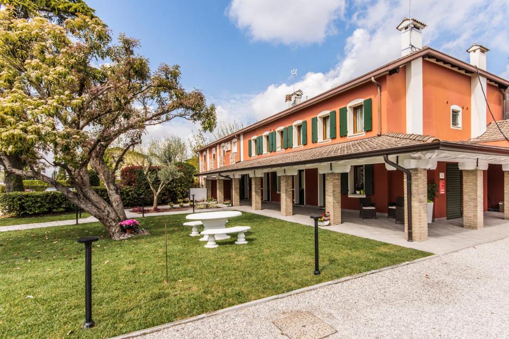 - un bâtiment avec une table de pique-nique dans la cour dans l'établissement Hotel Residence - Il Giardino del Cigno, à Latisana