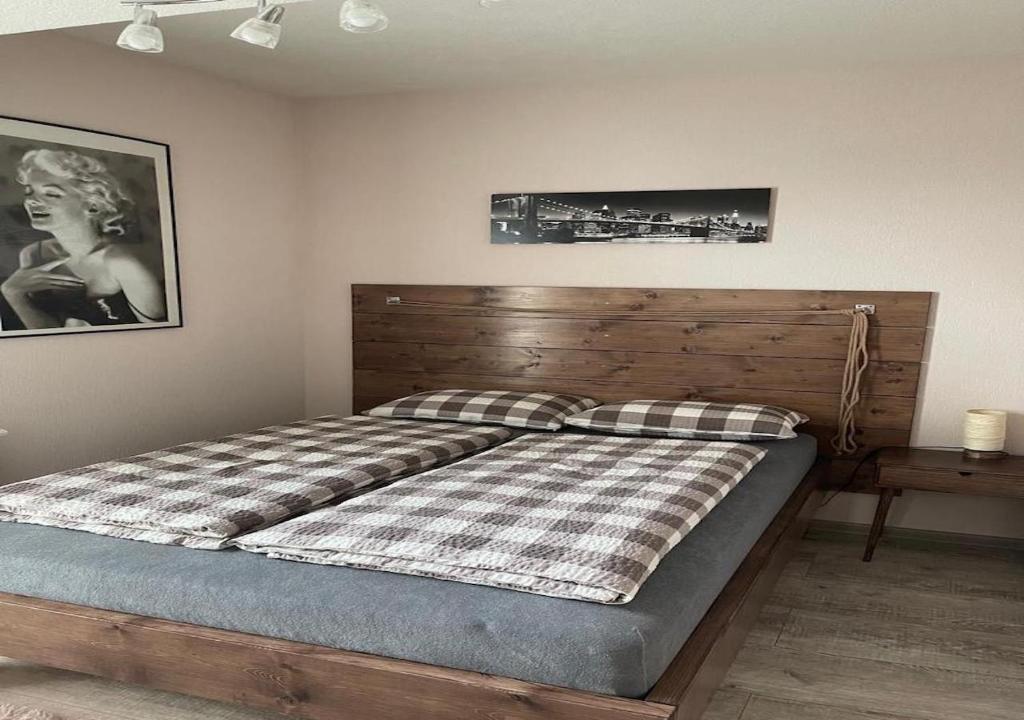 sypialnia z łóżkiem z drewnianym zagłówkiem i zdjęciem w obiekcie Apartamenty Bartnicza A w Bielsku Białej