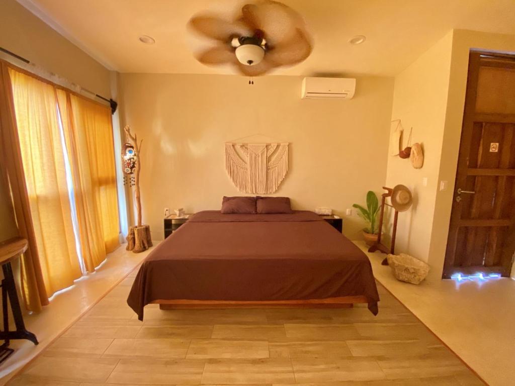 a bedroom with a bed and a ceiling fan at Aj Mun, Hotel Real Maya 3 in Valladolid
