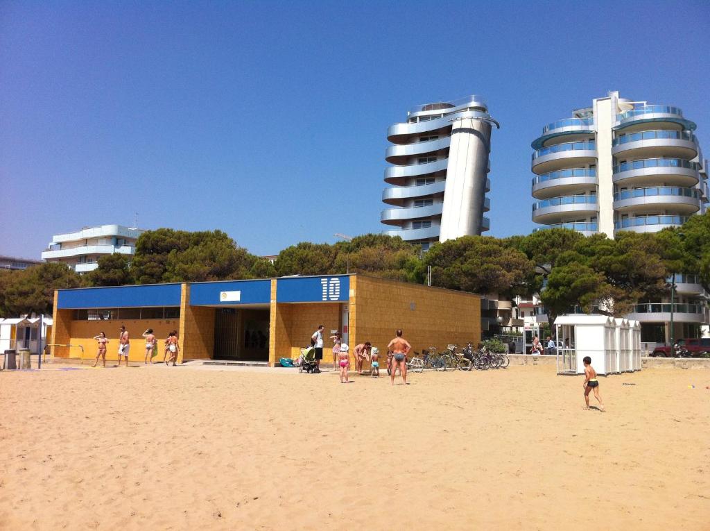 a group of people on the beach near a building at Hotel Bologna in Lignano Sabbiadoro