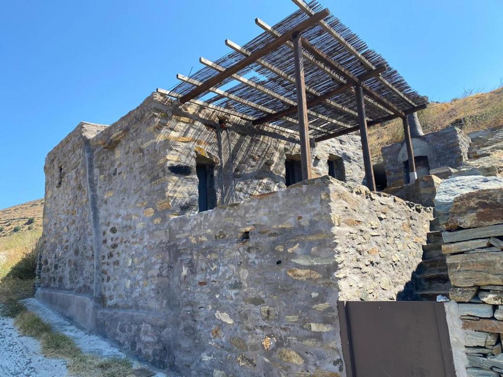 a stone building with a roof on top of it at Alonaki Tinos Rental Cottage house in Skaládhos