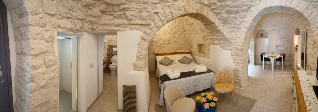 ein Schlafzimmer mit einem Bett in einer Steinmauer in der Unterkunft Trullo Monte Santo 50 in Alberobello