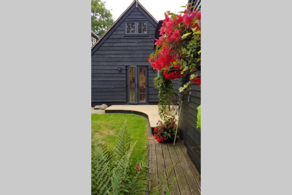 ein Haus mit Blumen davor in der Unterkunft Riverside Lodge Pied a Terre in Fordingbridge