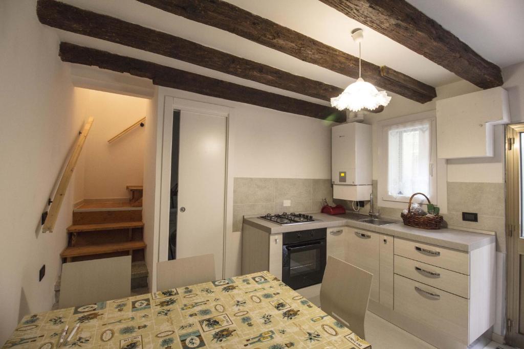 a kitchen with white cabinets and a stove top oven at Dimora Marchiada -apeliving- Pellestrina Ve in Pellestrina