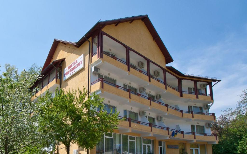 a building with balconies on the side of it at Hotel President in Băile Olăneşti