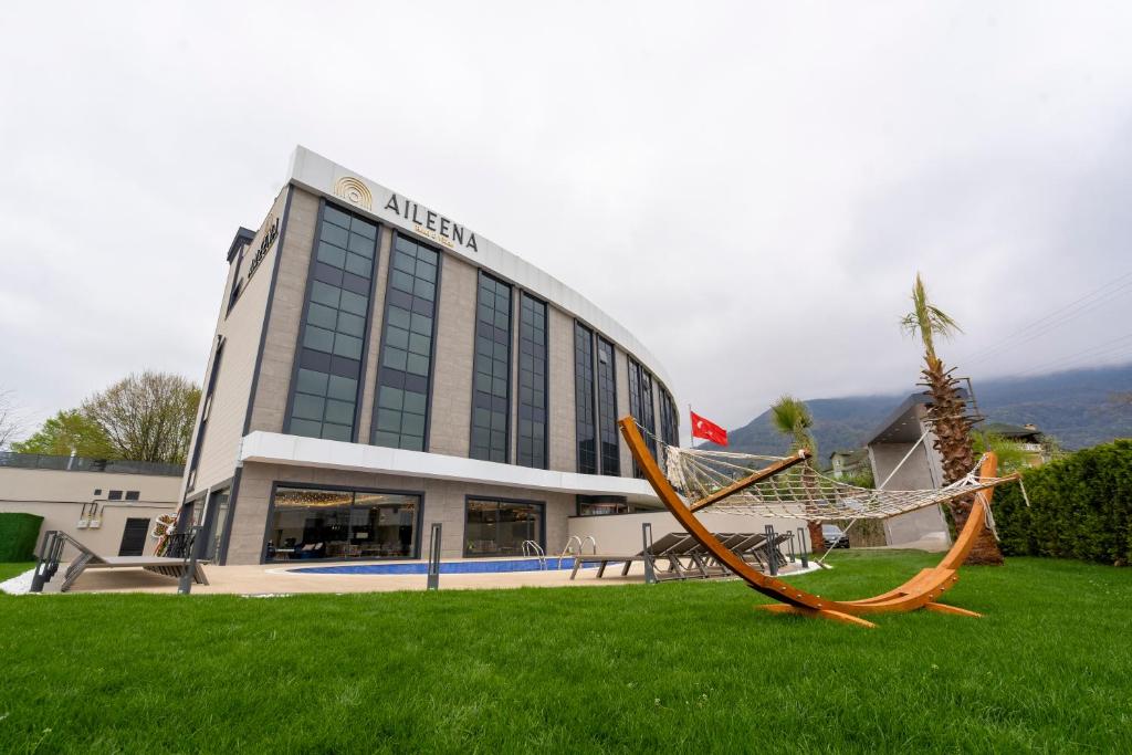a building with a hammock in the grass in front of it at Aileena Hotel & Villas in Kartepe