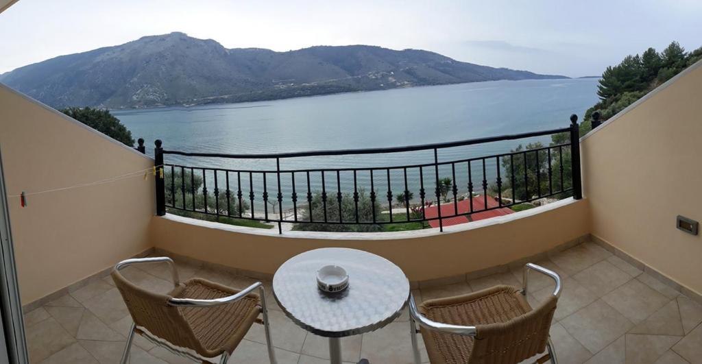 a balcony with a table and chairs and a view of the water at Plataria Palace in Plataria