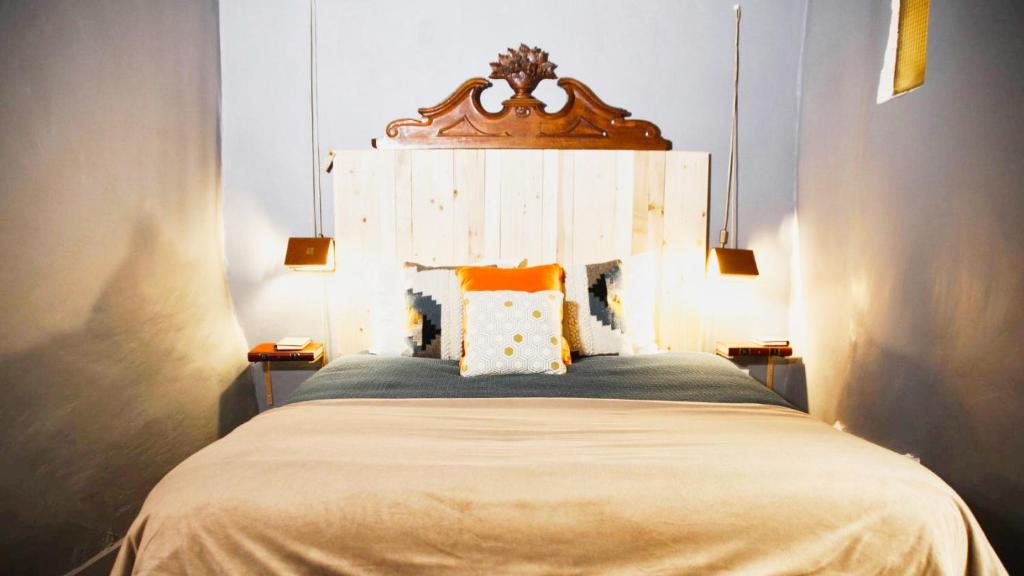 een slaapkamer met een bed met een houten hoofdeinde bij Le Bouquiniste, atypique, cosy, fibre, BedinShop in Romans-sur-Isère