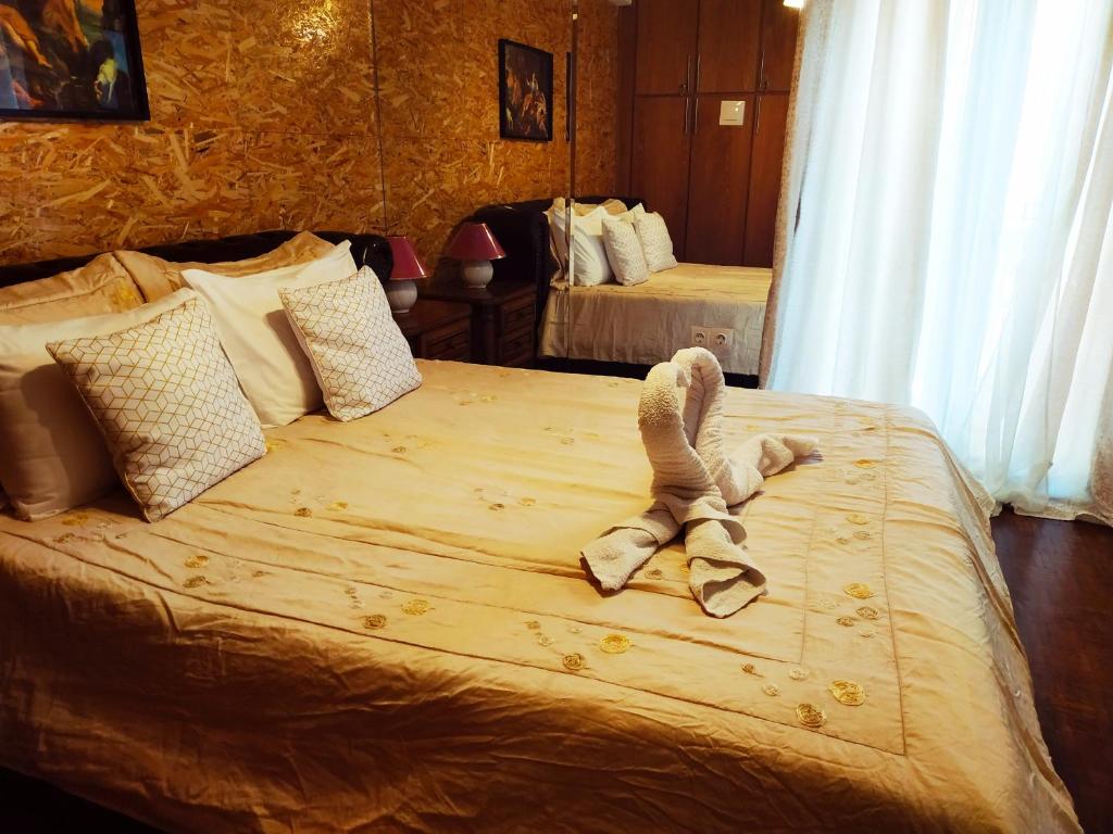ein Schlafzimmer mit einem Bett mit einem ausgestopften Tier darauf in der Unterkunft Superior Apartment in Korinthos