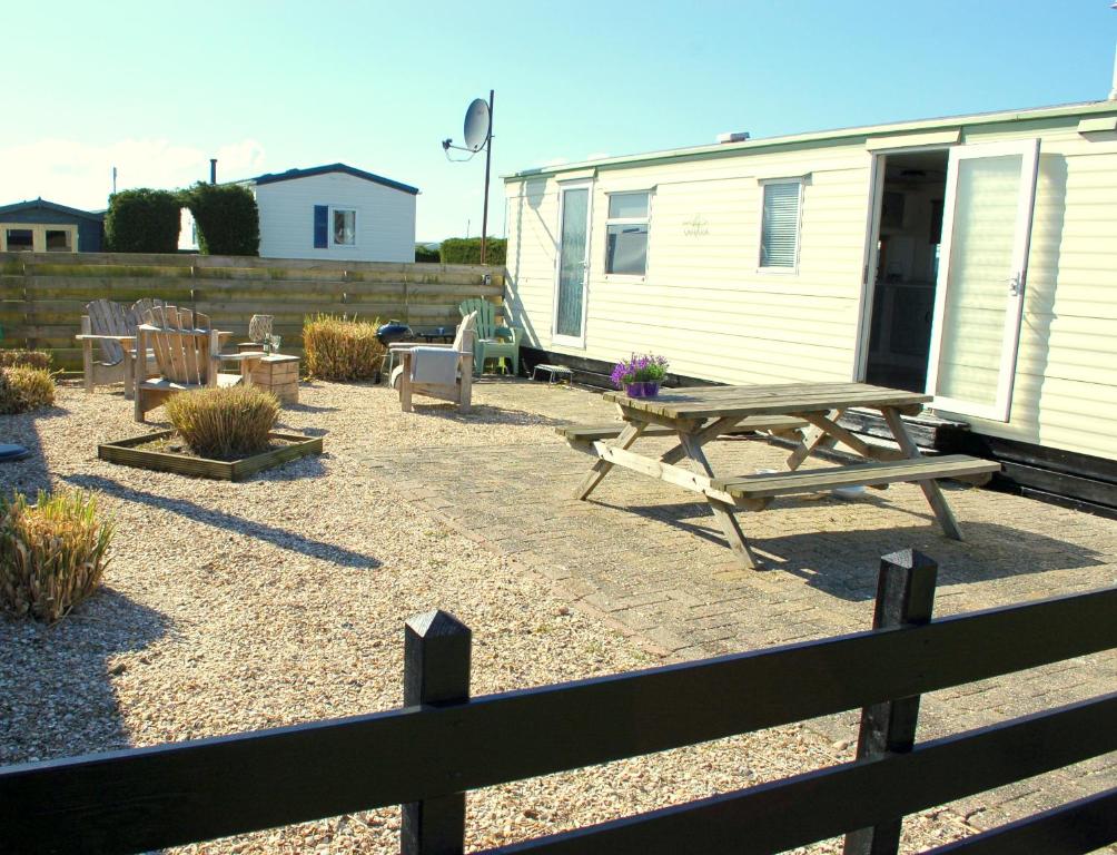 a backyard with a picnic table and a trailer at Chalet Wiron aan het Wad. in Westerland