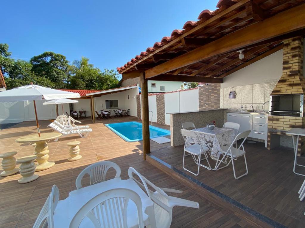 a patio with white chairs and a table at Pousada Nova Estrela da Canastra in Delfinópolis