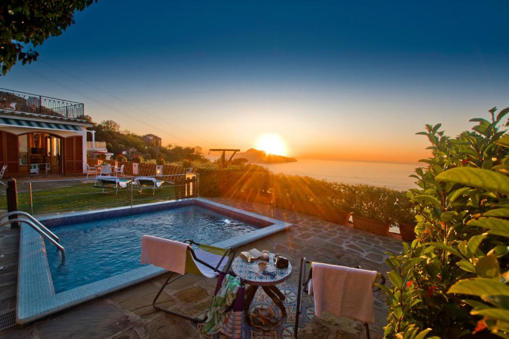 マッサ・ルブレンセにあるMiraCapri Villaのスイミングプールと夕日を望むヴィラ