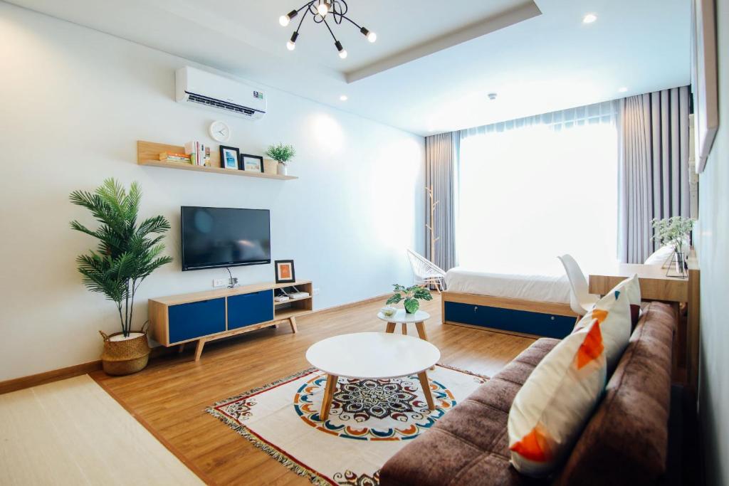 uma sala de estar com um sofá e uma mesa em May house Green Bay Garden Hạ Long - near Marina beach em Ha Long