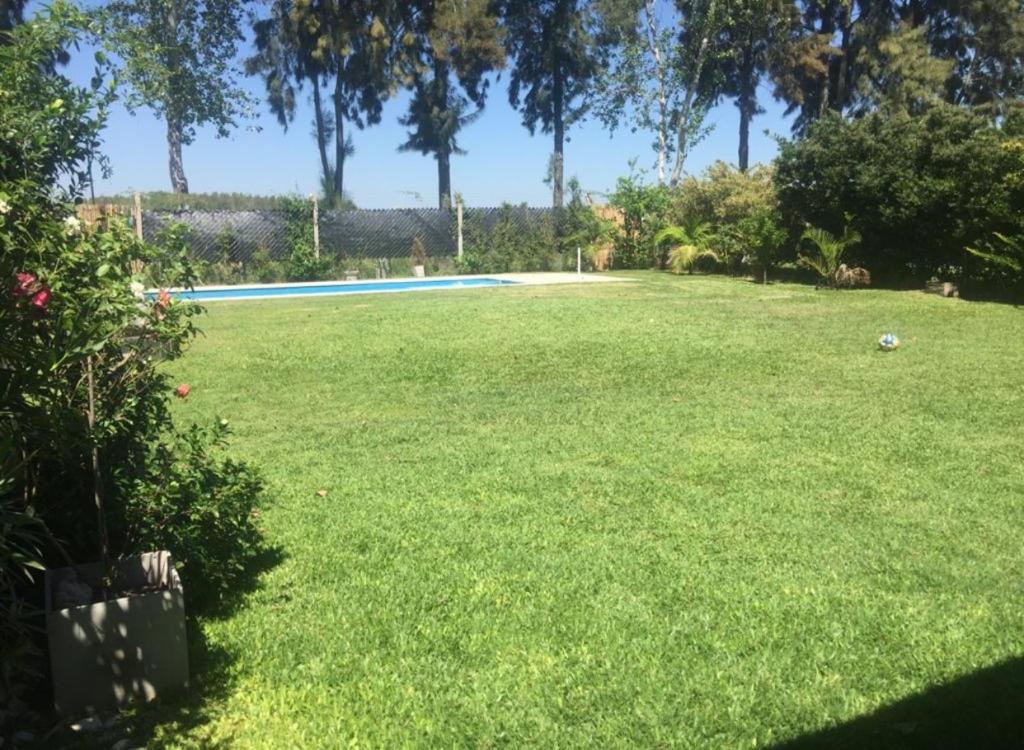 ein großer Garten mit einem Pool in der Mitte in der Unterkunft Barrio cerrado premium in Dique Luján