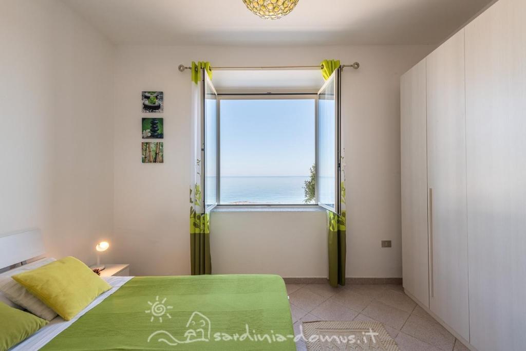 a bedroom with a bed and a large window at Casa Acqua Dolce in Cala Gonone