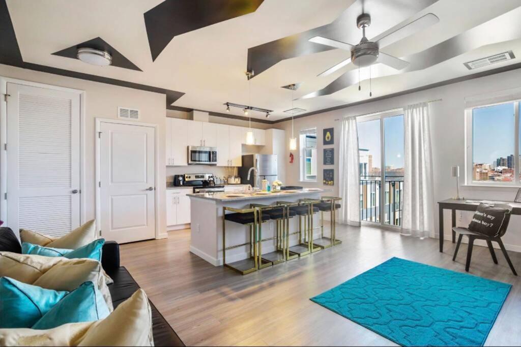 een woonkamer met een bank en een keuken bij Lux Penthouse Skyline, Views Gym , Free Parking & Wifi in Baltimore