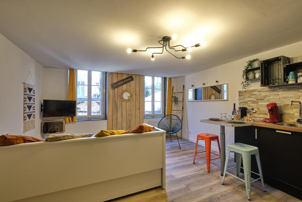 - une cuisine et un salon avec un comptoir et une table dans l'établissement Méline - BASTIDE - Appartement proche place Carnot proche cité médiéval, à Carcassonne