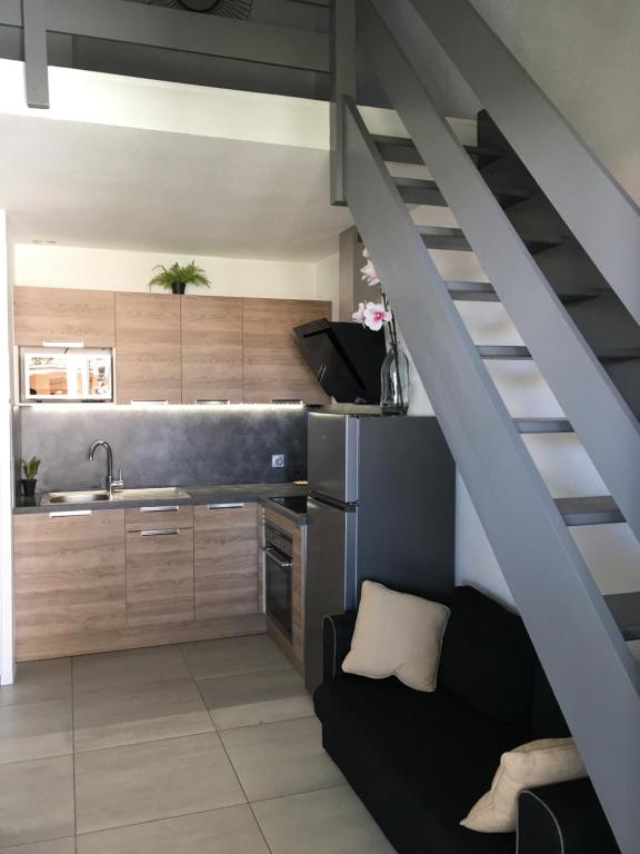 a kitchen with a staircase leading up to a loft at Cosy Lagune in Saint-Cyprien