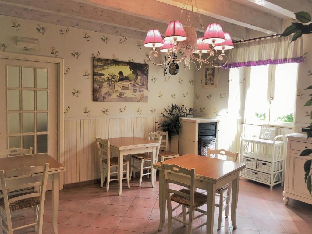 un comedor con mesas y sillas y una lámpara de araña en Bed & Breakfast De Nittis, en Barletta