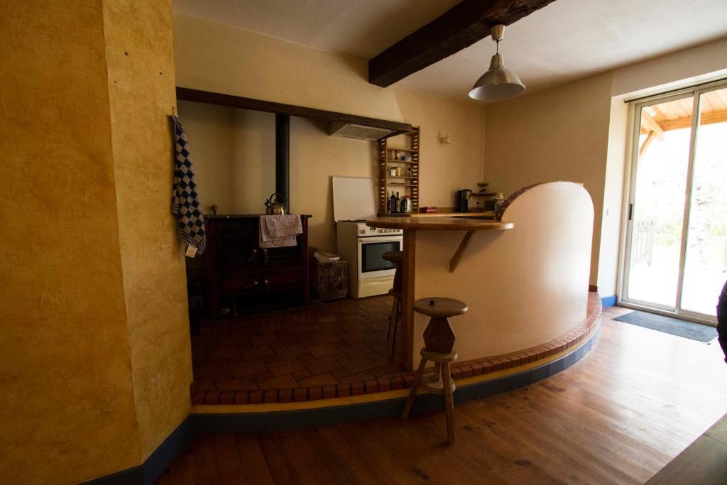 a room with a kitchen with a counter and a table at Gite d&#39;étape Les Diligences in Roquefixade