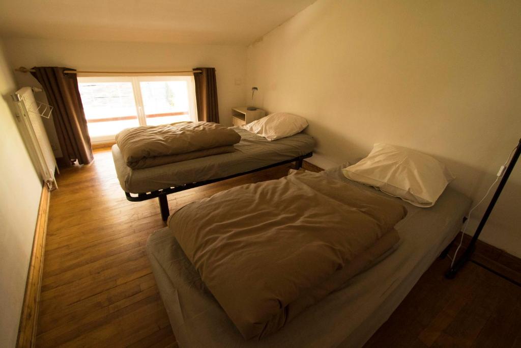 two beds in a small room with a window at Gite d&#39;étape Les Diligences in Roquefixade