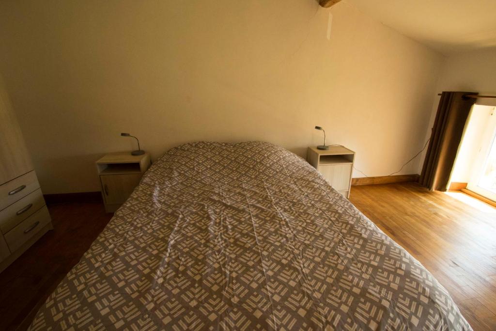 a bedroom with a bed and two lamps on two tables at Gite d&#39;étape Les Diligences in Roquefixade