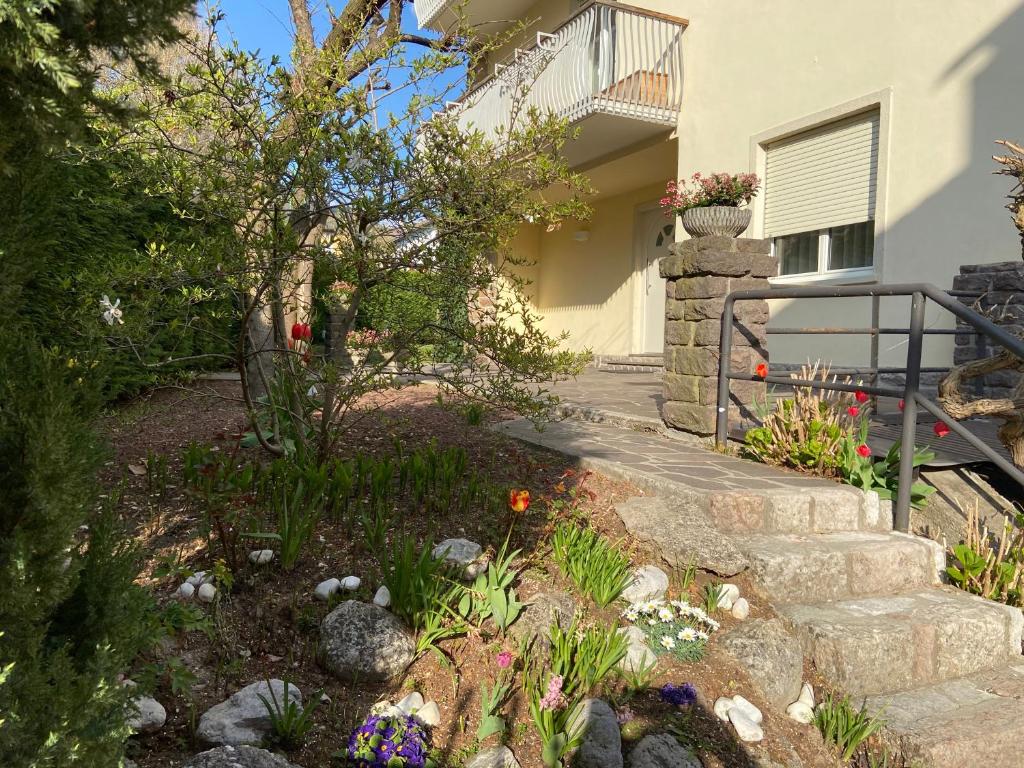 un jardin devant une maison avec des fleurs dans l'établissement Casa Bosco, à Levico Terme