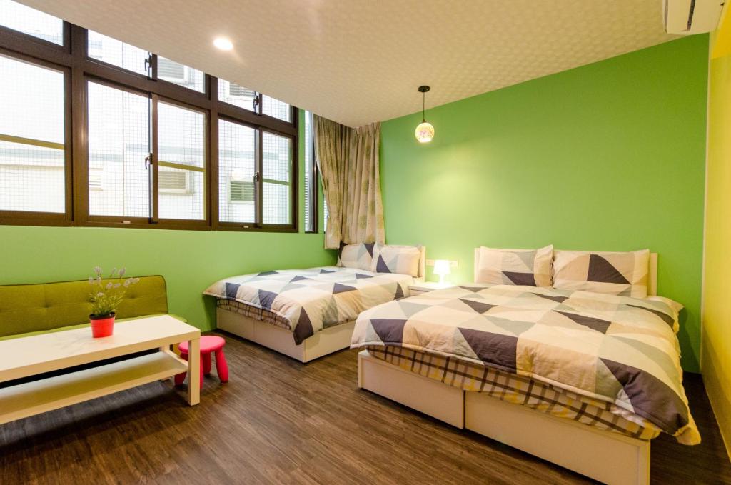 羅東鎮的住宿－遇見小太陽，一间卧室设有两张床和绿色的墙壁