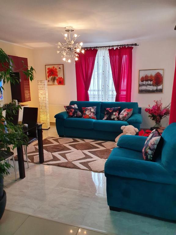 a living room with blue couches and pink curtains at Green Village Bran in Bran
