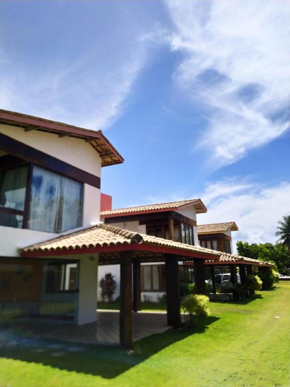 a house with a green lawn in front of it at Casa frente mar com vista incrível! in Vera Cruz de Itaparica