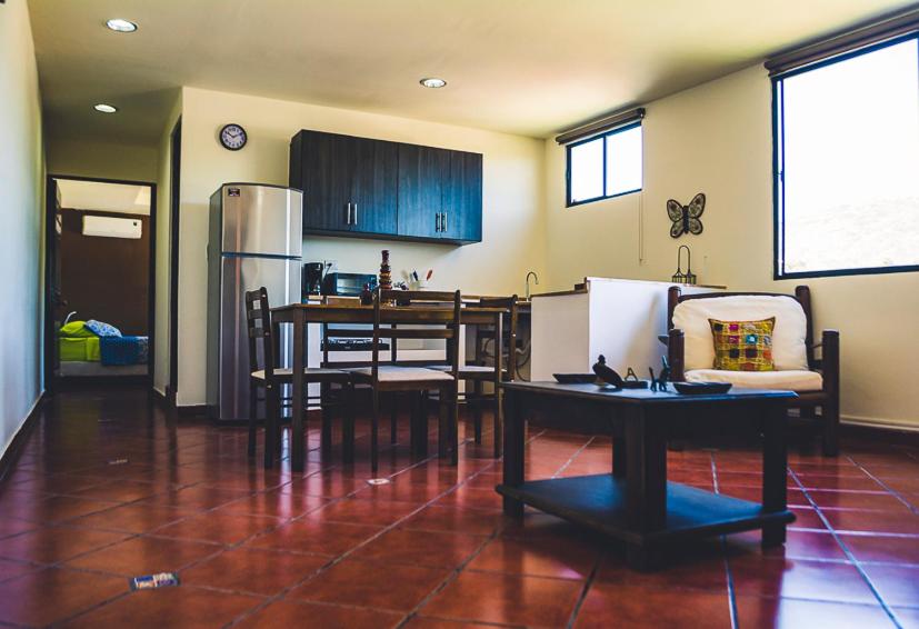Villa Stahl في سان سلفادور: مطبخ وغرفة طعام مع طاولة وثلاجة