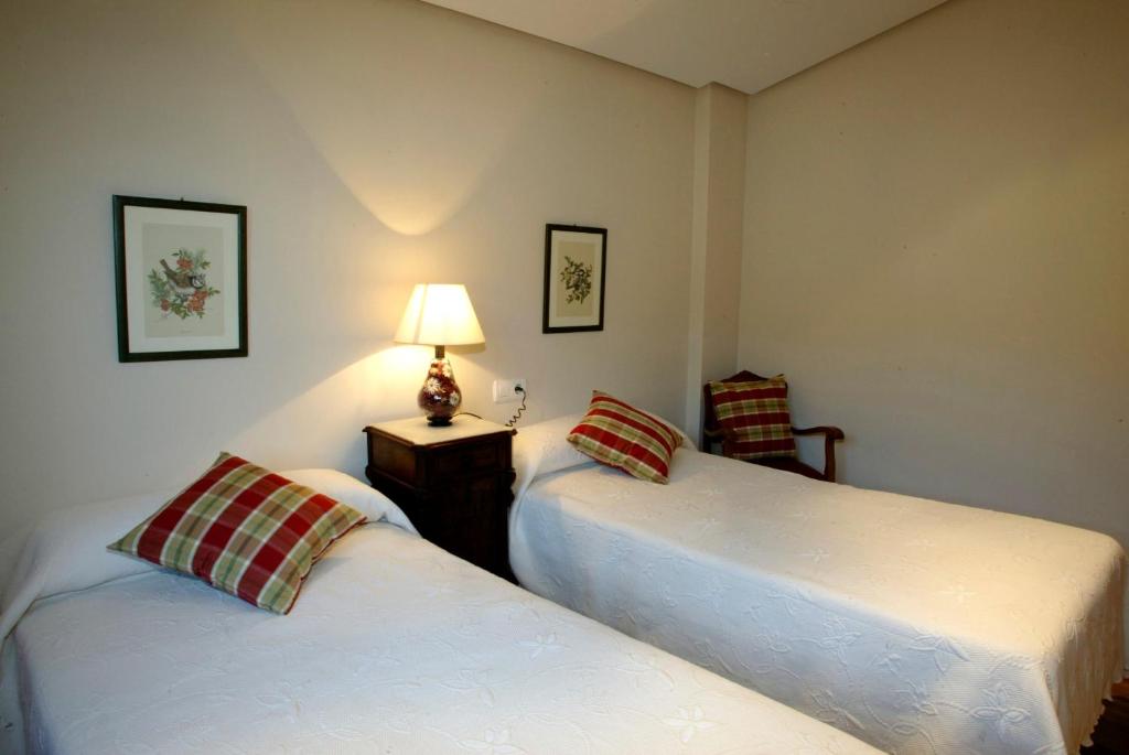 1 dormitorio con 2 camas y una lámpara en una mesa en URDINETXE en Luyando