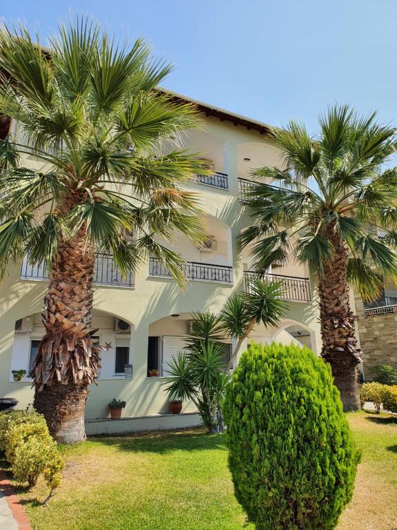 two palm trees in front of a building at Hotel Pefko in Neos Marmaras
