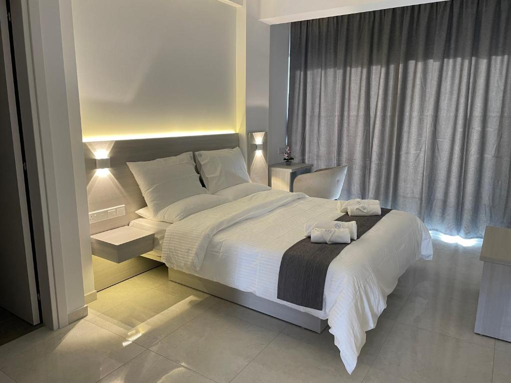 Un dormitorio con una cama grande y una ventana en La Veranda Hotel, en Lárnaca