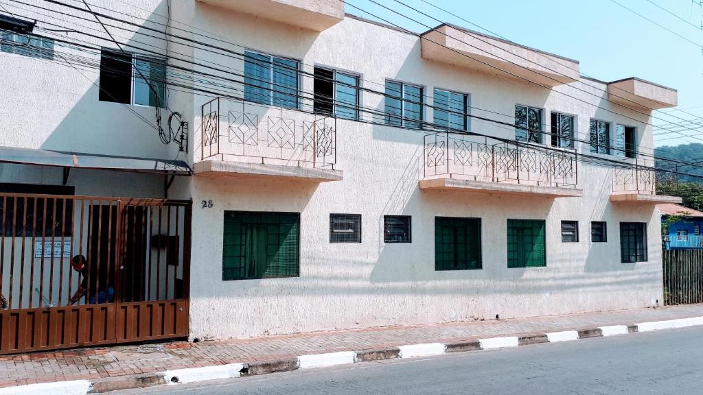 a white building with balconies on the side of it at Hospedaria São Benedito in Guararema