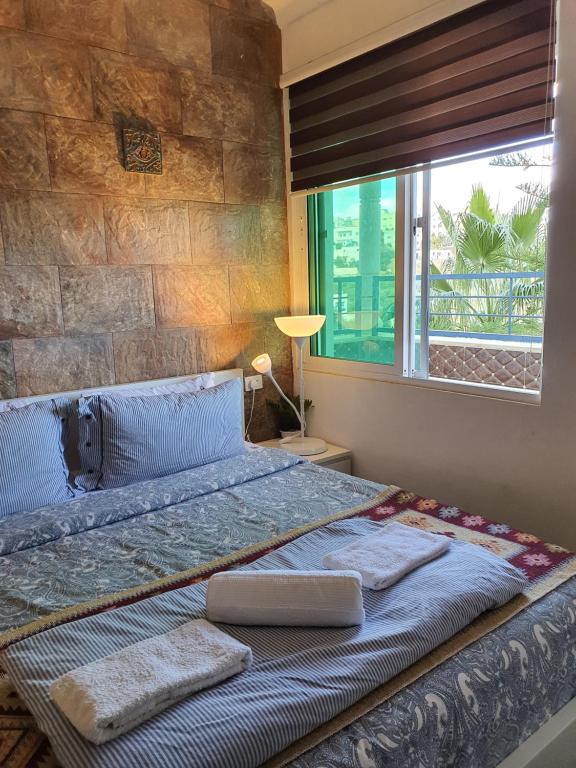 una camera da letto con un grande letto e un muro in pietra di Full Panorama To Archaeological Site Jarash a Jerash