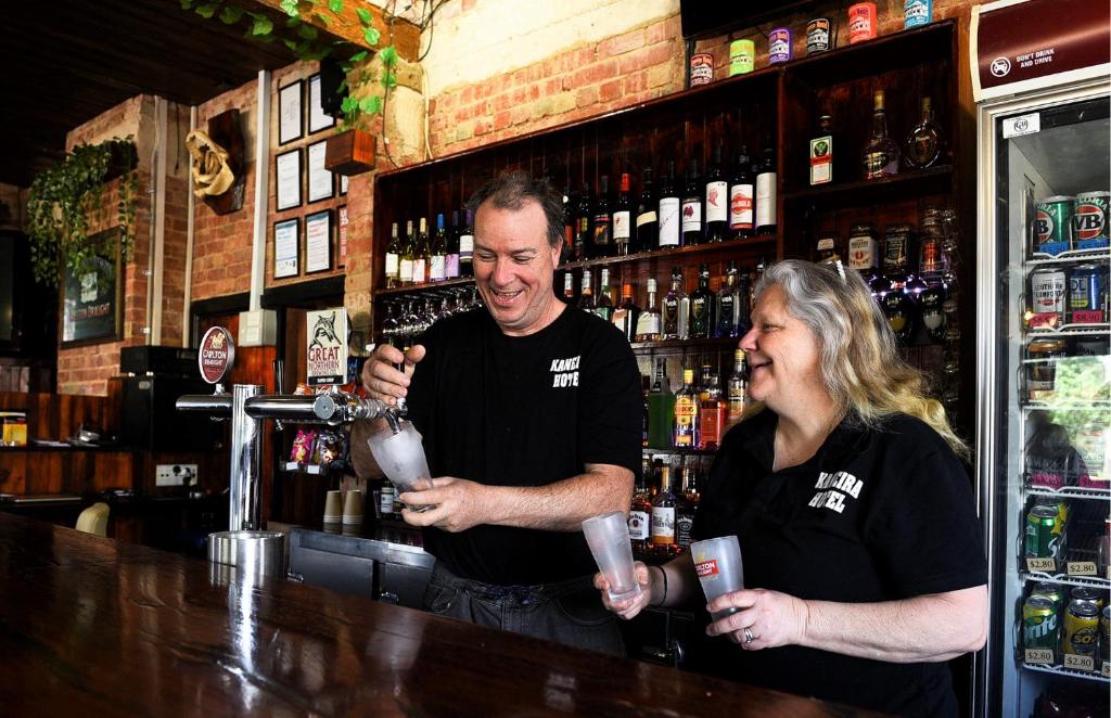 a man and a woman standing behind a bar at Kaneira Hotel in Culgoa
