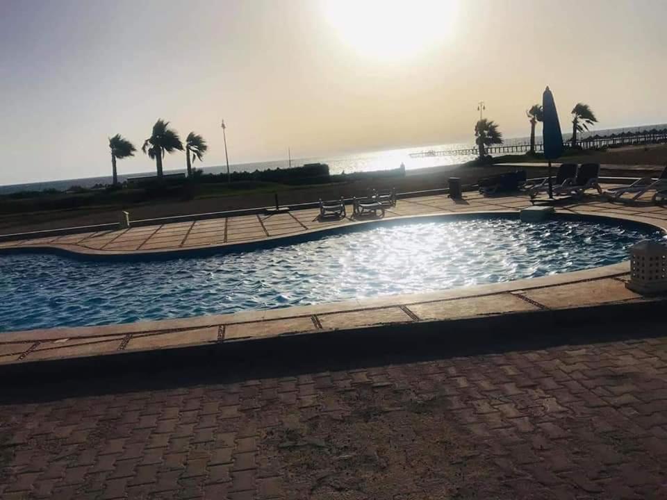 una gran piscina en un parque con palmeras en Seaview Chalets in Porto South Beach - Families only, en Ain Sokhna