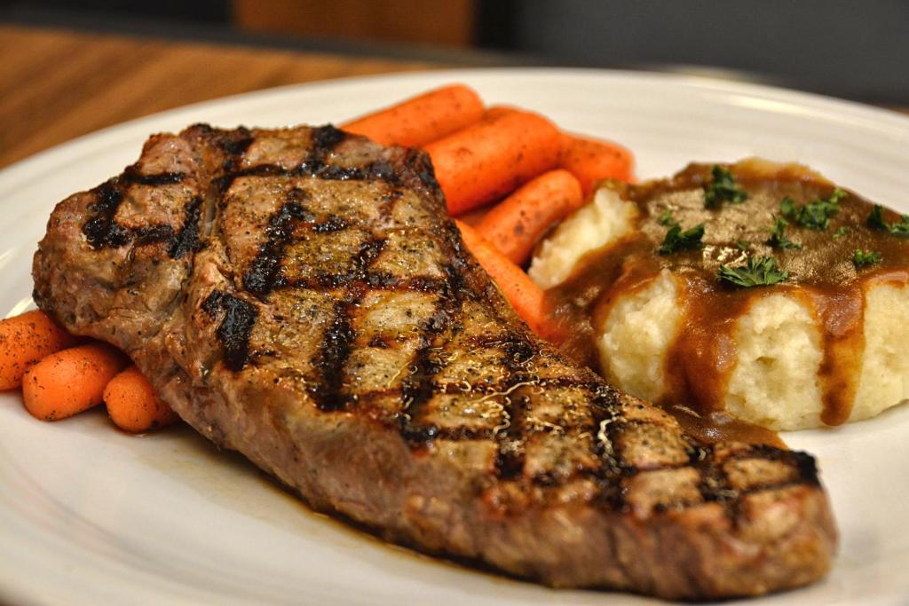 a plate with steak and carrots on a table at Gold Country Casino Resort in Oroville