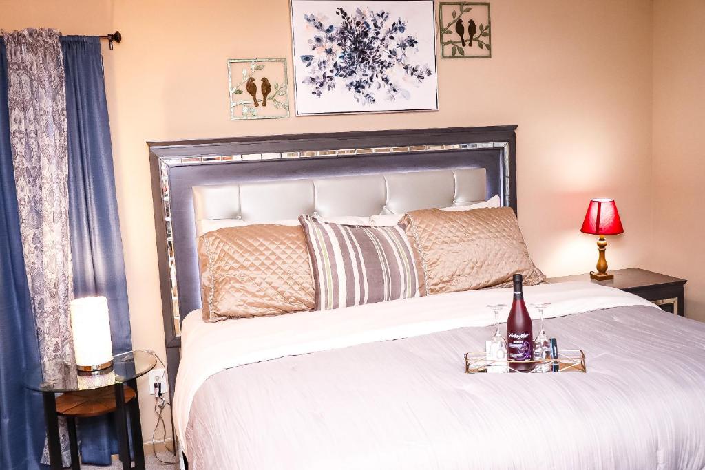 ein Schlafzimmer mit einem großen Bett und einer Flasche Wein in der Unterkunft Easy Access luxurious kingbed with facilities yet to be opened in Norcross