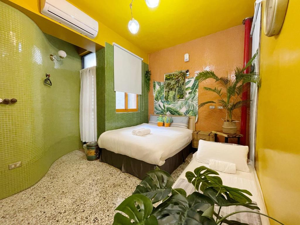 two beds in a room with plants at Sennong Homestay in Tainan