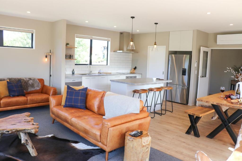 a living room with a couch and a kitchen at Fivestone Lodge in Lake Tekapo