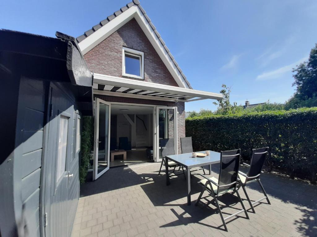 a patio with a table and chairs in front of a house at Aanloop 34 in Domburg