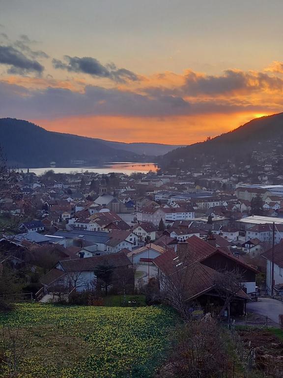 a view of a town at sunset with a city at Entre Montagne et lac in Gérardmer