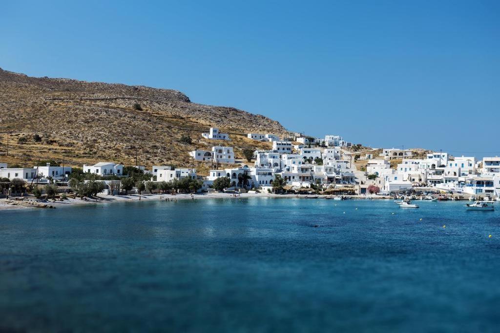 a group of white houses on a hill next to the water at Family house by the seaside of Karavostasis in Karavostasi