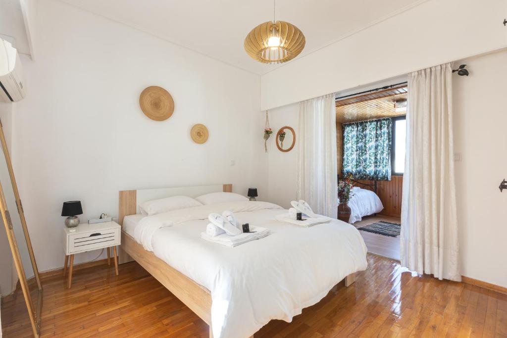 a bedroom with a large white bed and a window at Penthouse Project – Rooftop Chasers Ideal in Athens